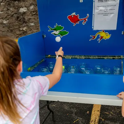 Child playing a ping pong toss style game in the family fun area