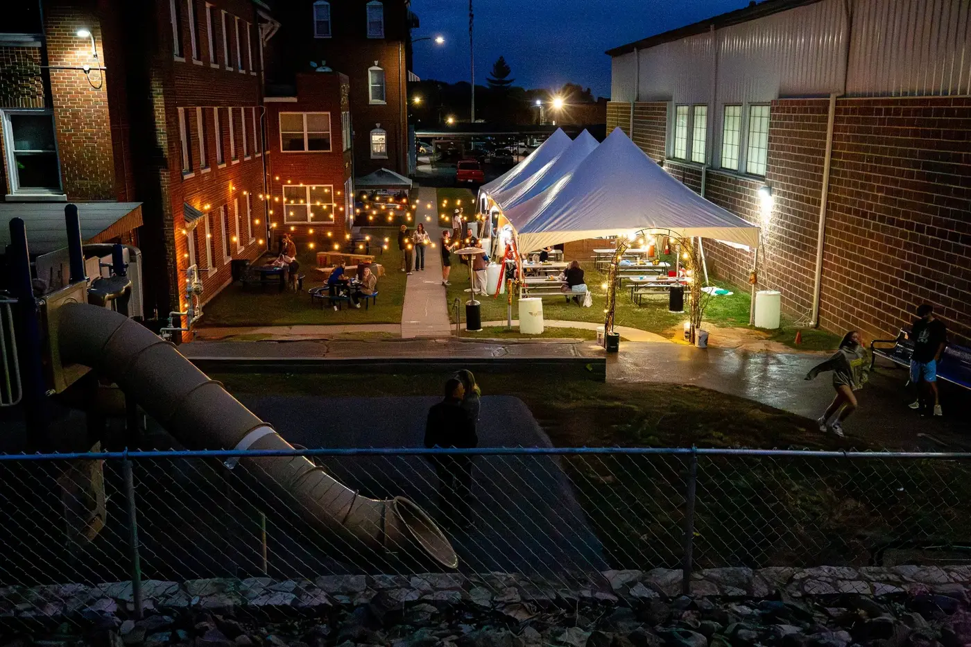 Lighted tents and guests on the Oktoberfest grounds at night