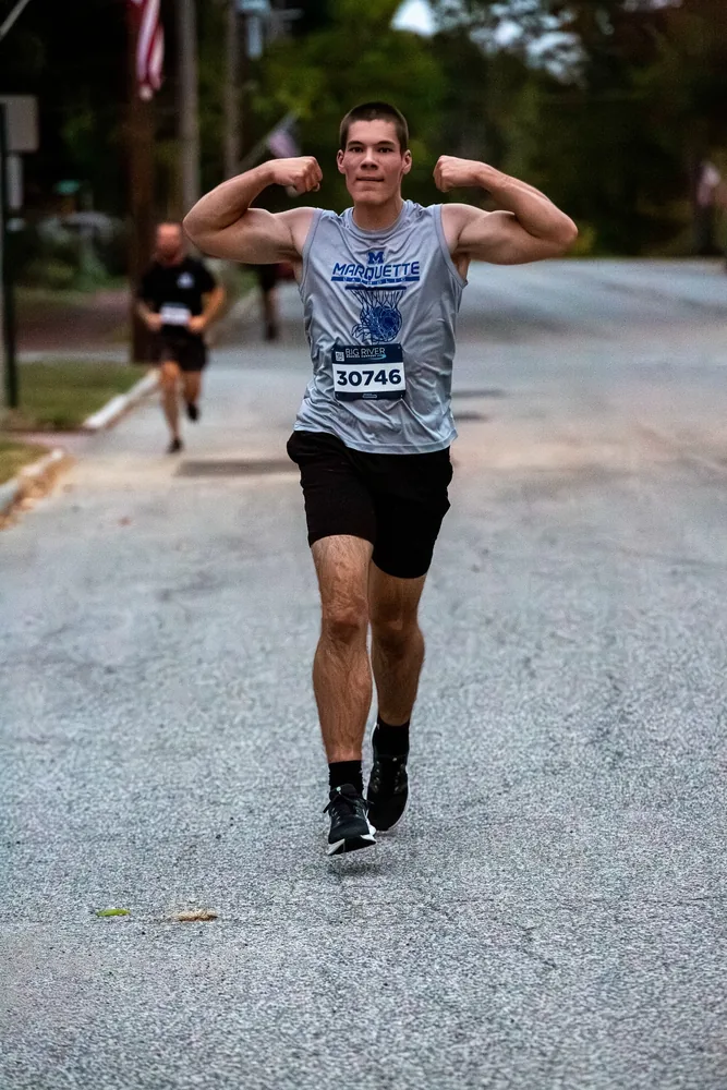 Runner flexing while finishing strong on the Oktoberfest course